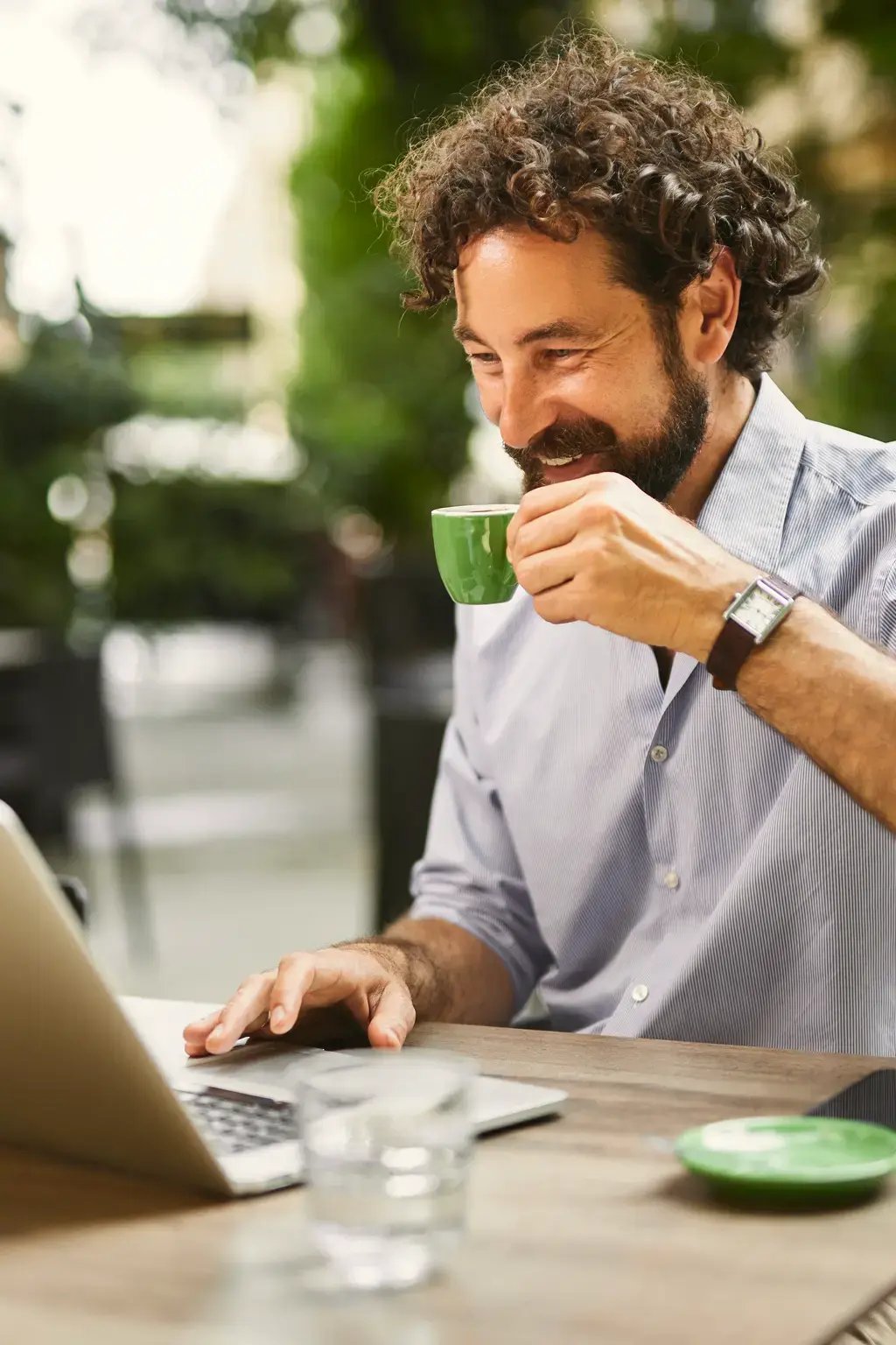 Homme buvant son café devant son ordinateur